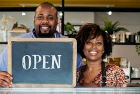 Store Owners holding Open Sign Store Owners holding Open Sign
