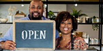 Store Owners holding Open Sign Store Owners holding Open Sign
